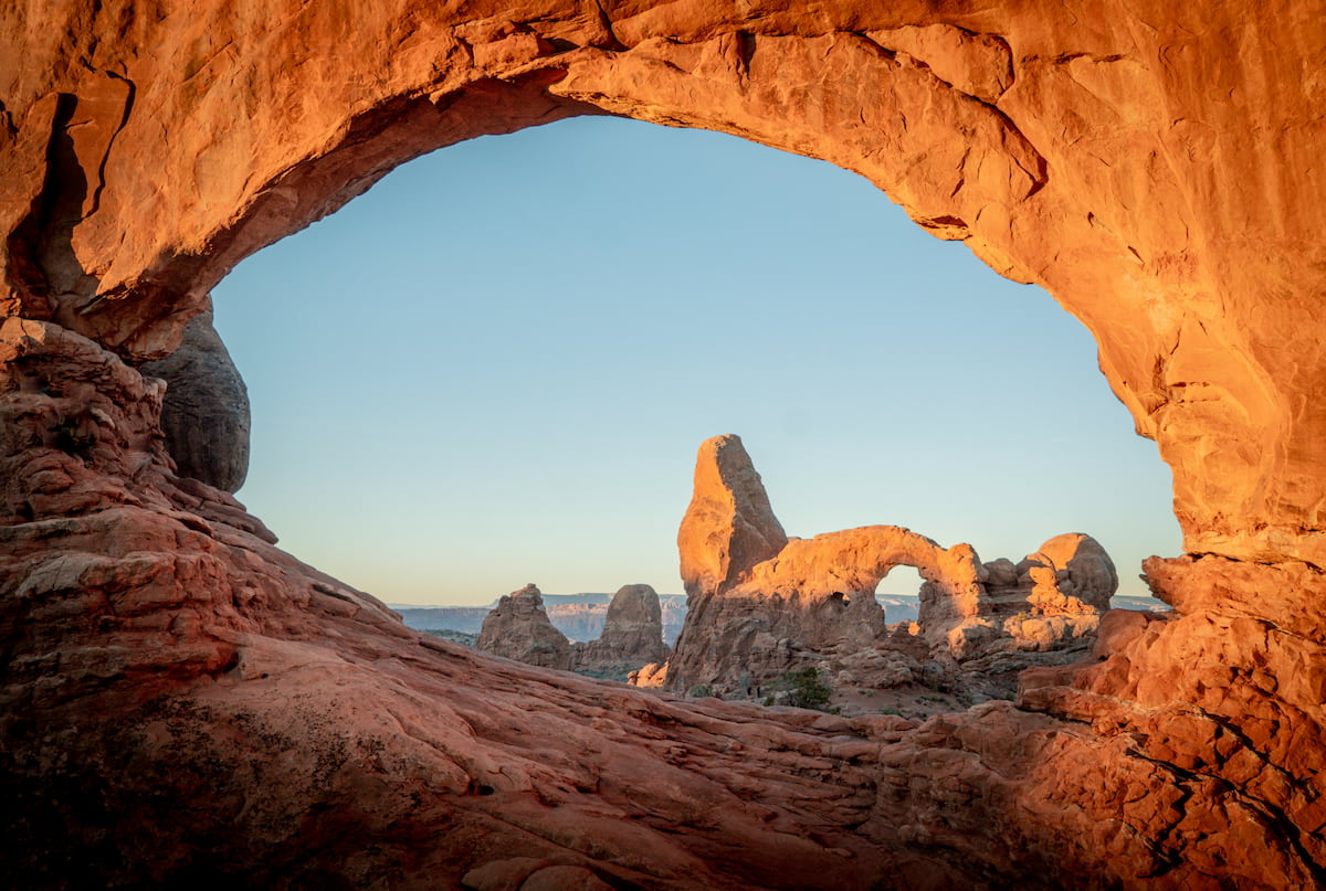 Iconic Delicate Arch standing alone against a blue sky.