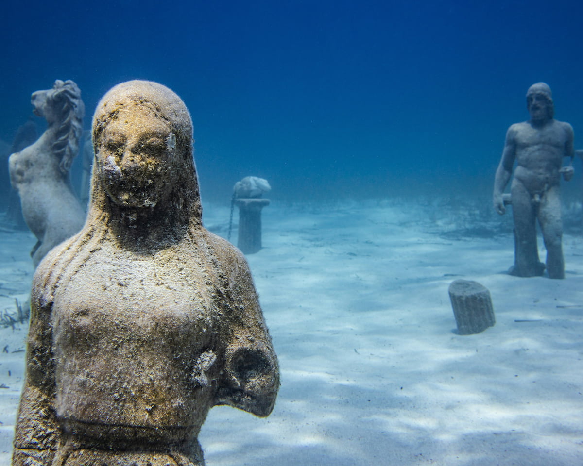 Underwater ruins with statues, evoking the Atlantis myth.